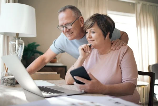 middle-aged couple looking at laptop together liking what they are seeing