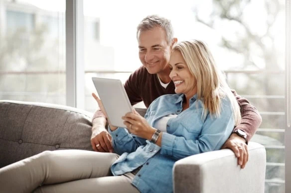 They do screen time as a couple. Shot of a mature couple using a digital tablet while relaxing together on the sofa at home.