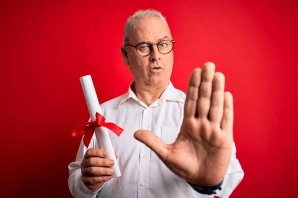 middle-aged man holding out hand signaling to stop while holding a rolled up piece of paper with a bow