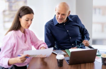 middle aged man meeting with financial advisor to look at chart 1200
