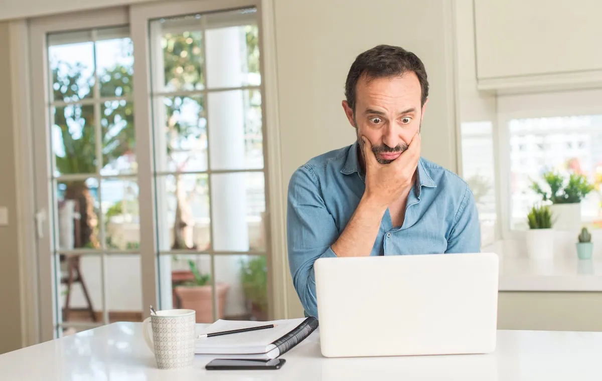 Fuel or Fire? Mastering Margin Lending Without Getting Burned 3 middle aged man shocked while looking at laptop at kitchen counter