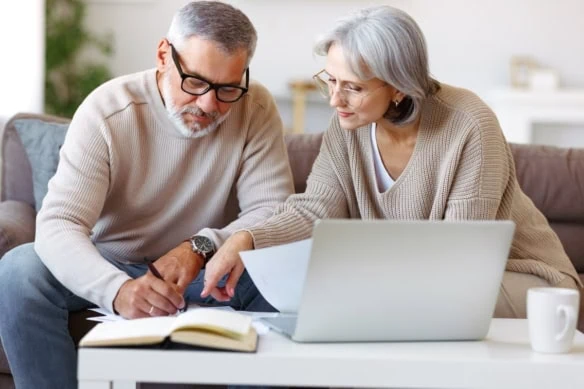 Smiling senior couple calculate expenses or planning budget together, reading notification letter with good news from bank , retired family husband and wife paying bills online on laptop