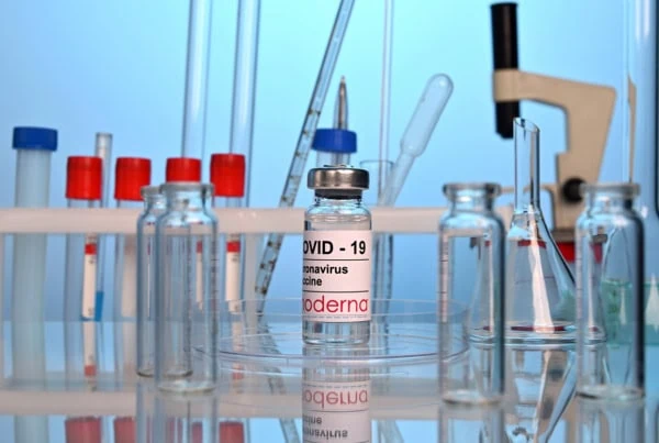 A vial of Moderna's COVID-19 vaccine sits on a lab table.