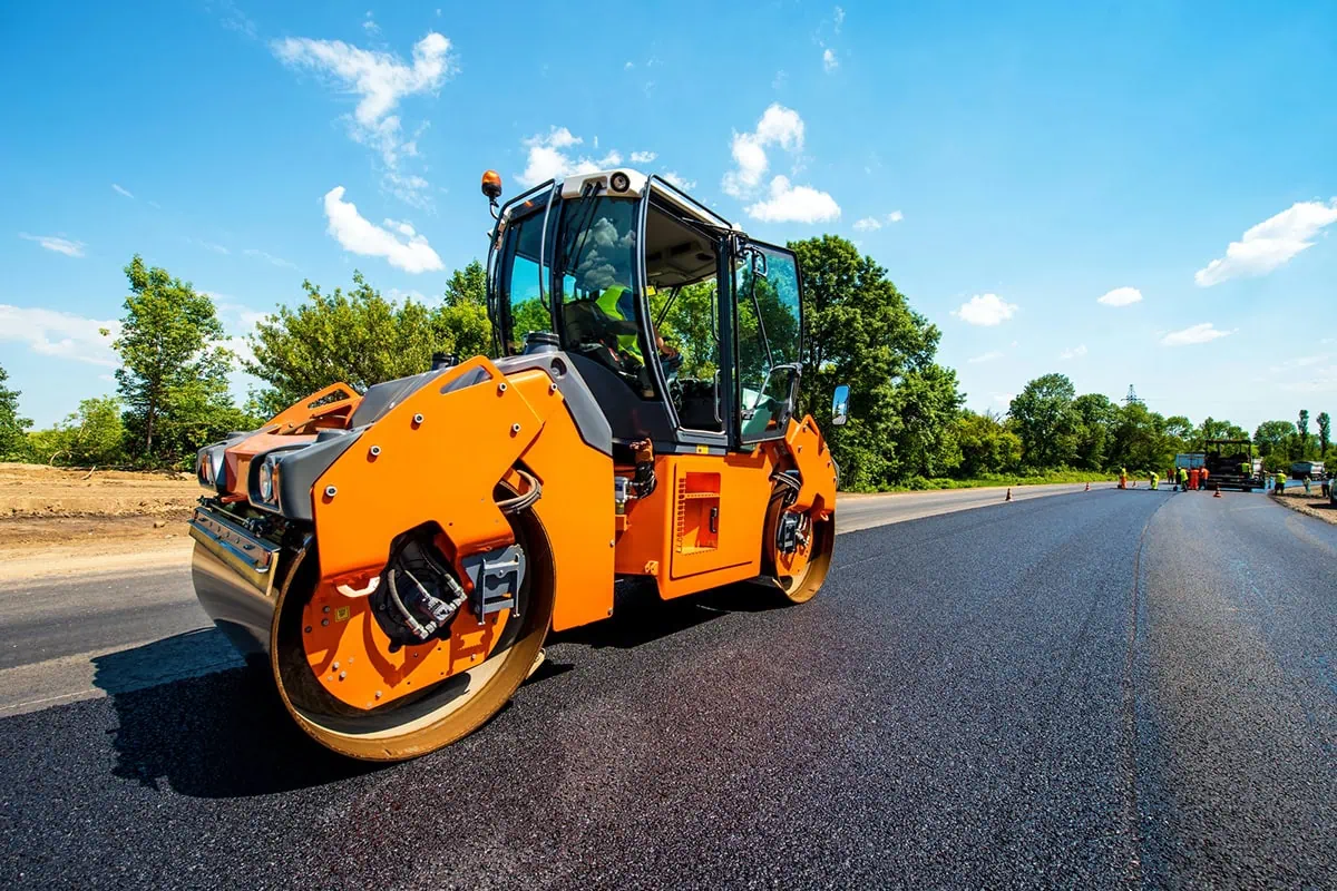 a pavement roller smoothing out a newly constructed road.