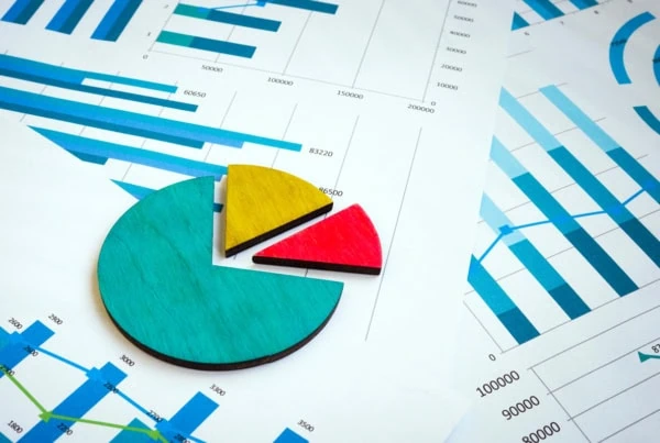 a pie chart sitting on top of some business documents.