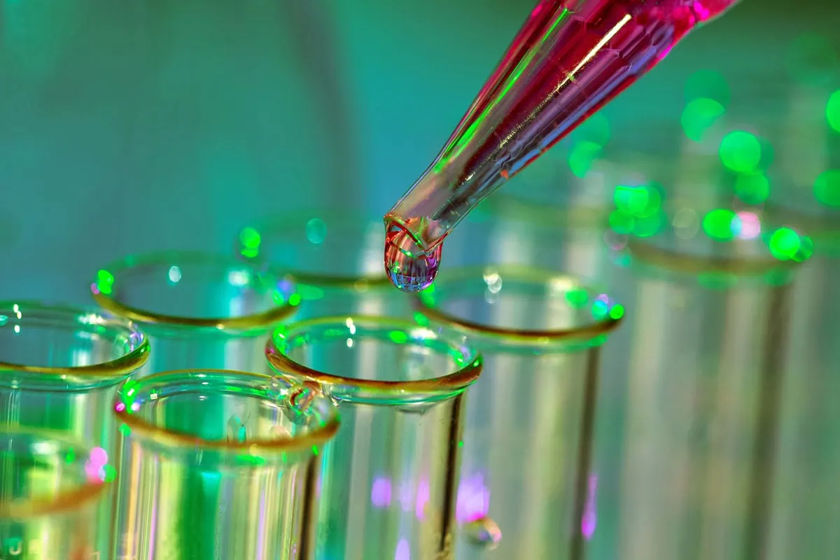 pipette adding fluid to one of several test tubes.