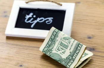 a chalkboard that says tips and a one dollar bill near it.