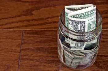 a jar filled with one dollar bills.