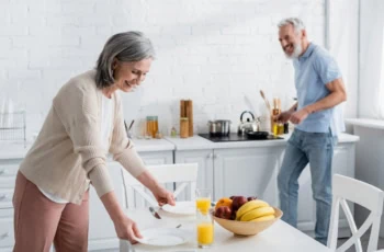 older couple cleaning kitchen happy