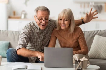 senior spouses smiling at computer happy