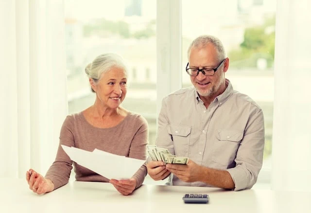 senior couple with money and calculator at home