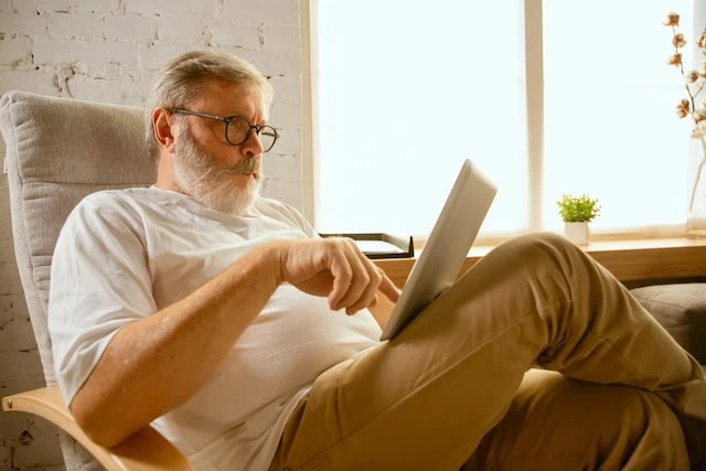 Senior man working with tablet at home - concept of home studying