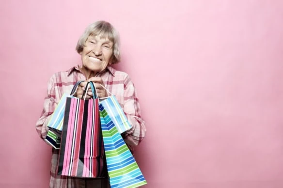 older woman smiling with shopping bags