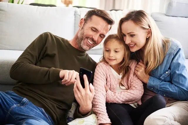 young family looking at finances on phone