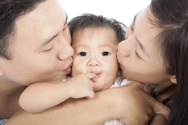 parents kissing baby