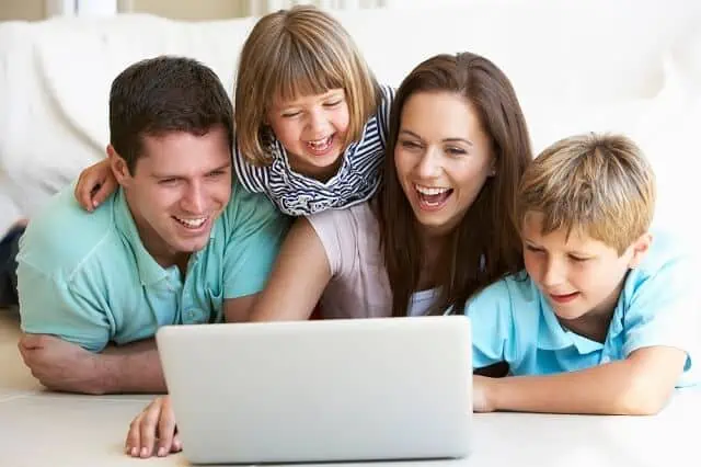 parents with kids laughing on computer