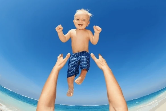 potential child tax credit changes father tossing child in air at beach