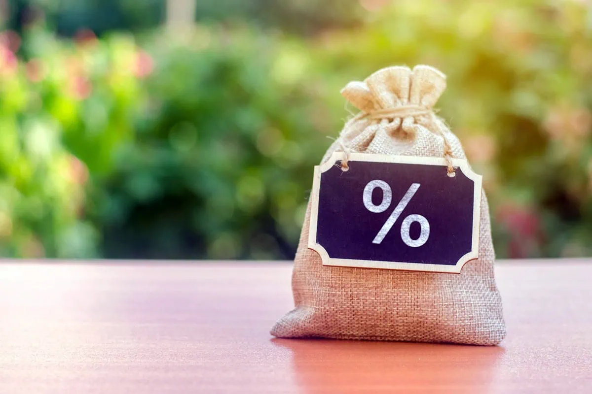 Want Stock Funds Yielding 5%-6%? I 'Prefer' These 3 ETFs 2 a sack of money with a percent sign chalkboard hanging on it from its neck.