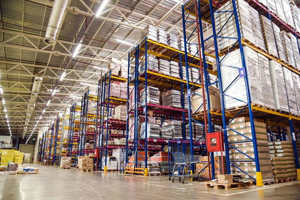 the inside of a large warehouse with stocked shelves.