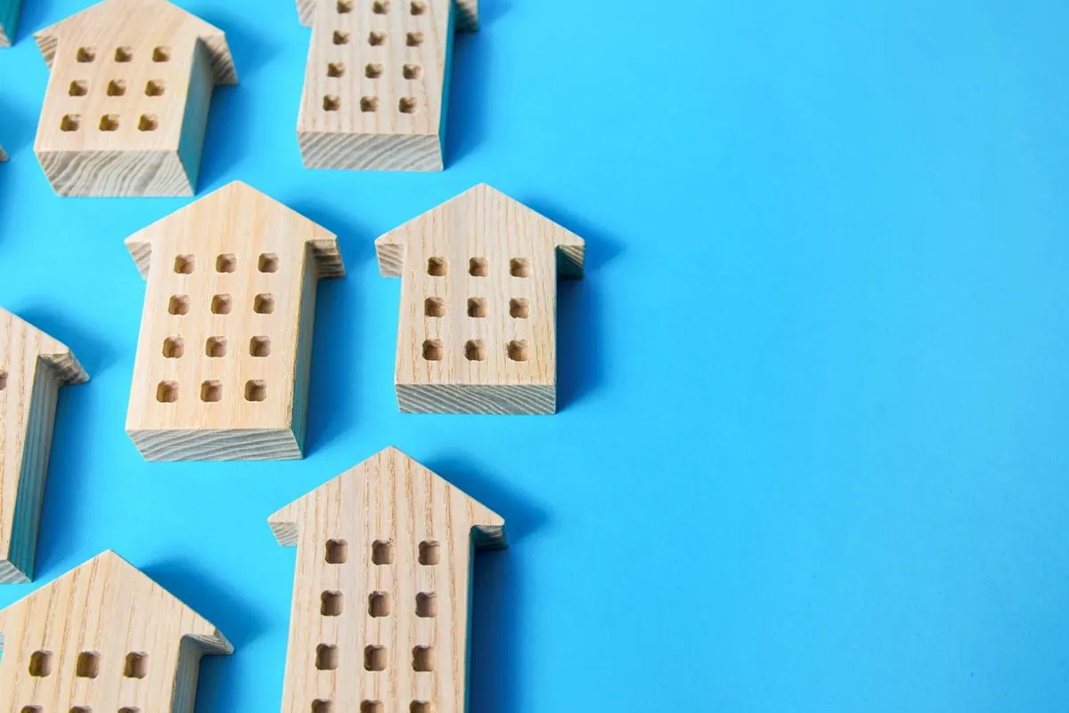 wooden houses against a blue background.