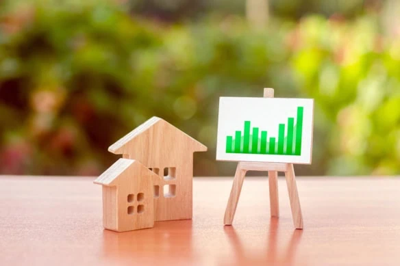 wooden houses and a chart showing growth on an easel.