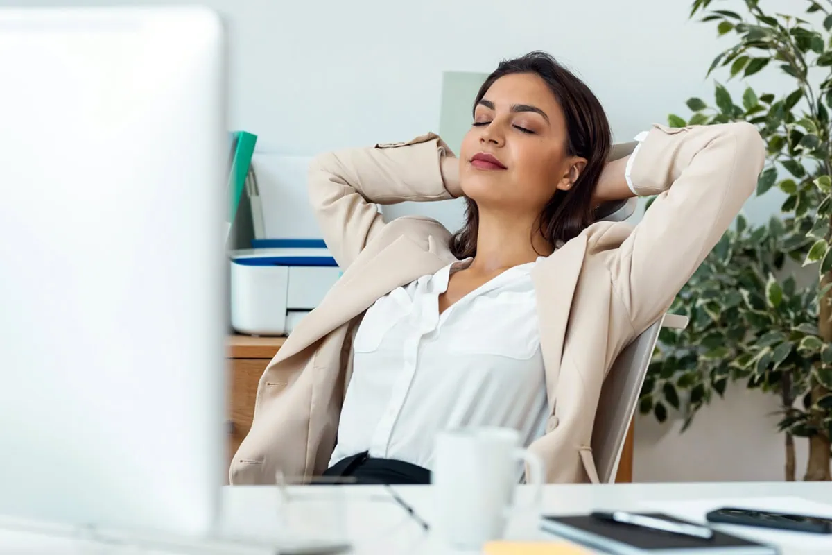 a businesswoman relaxes at her desk.