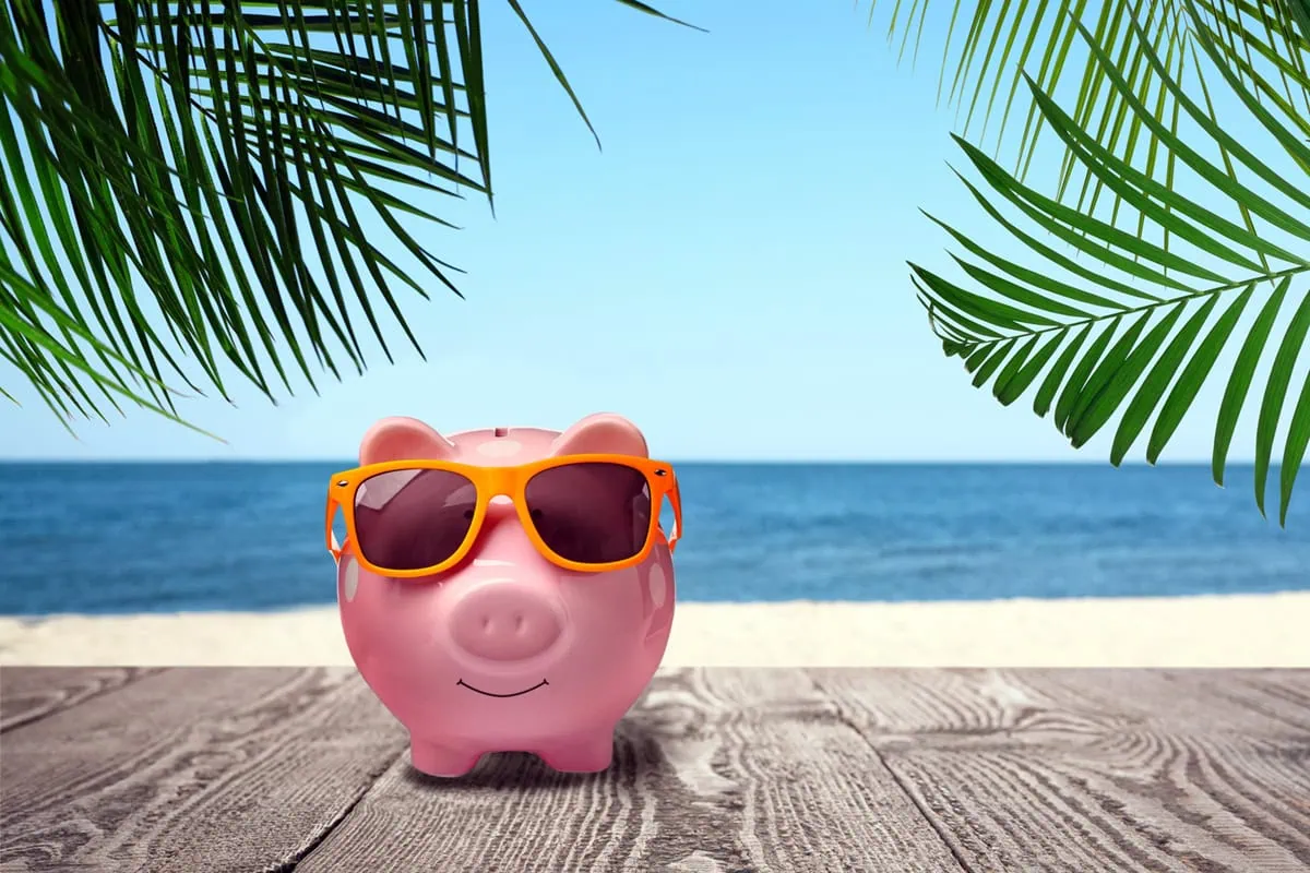 The Transformation from Spender to Saver: A Roadmap on Saving for Retirement 3 a piggy bank wears sunglasses while standing on a boardwalk.