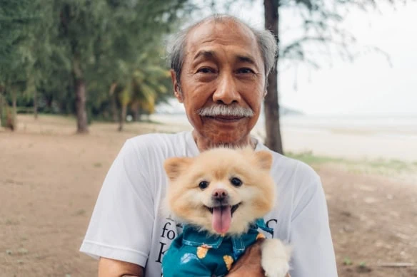 retiree holding a pet dog