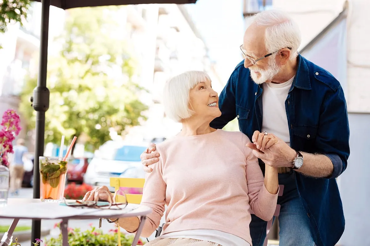 The Post-Resignation Safety Net: Securing Your Health Insurance on Your Own Terms 2 a couple looks lovingly at each other while outside at a patio table.