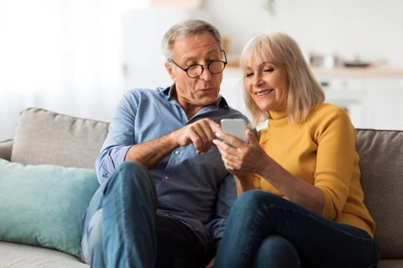 a happy older couple looking at a smartphone.