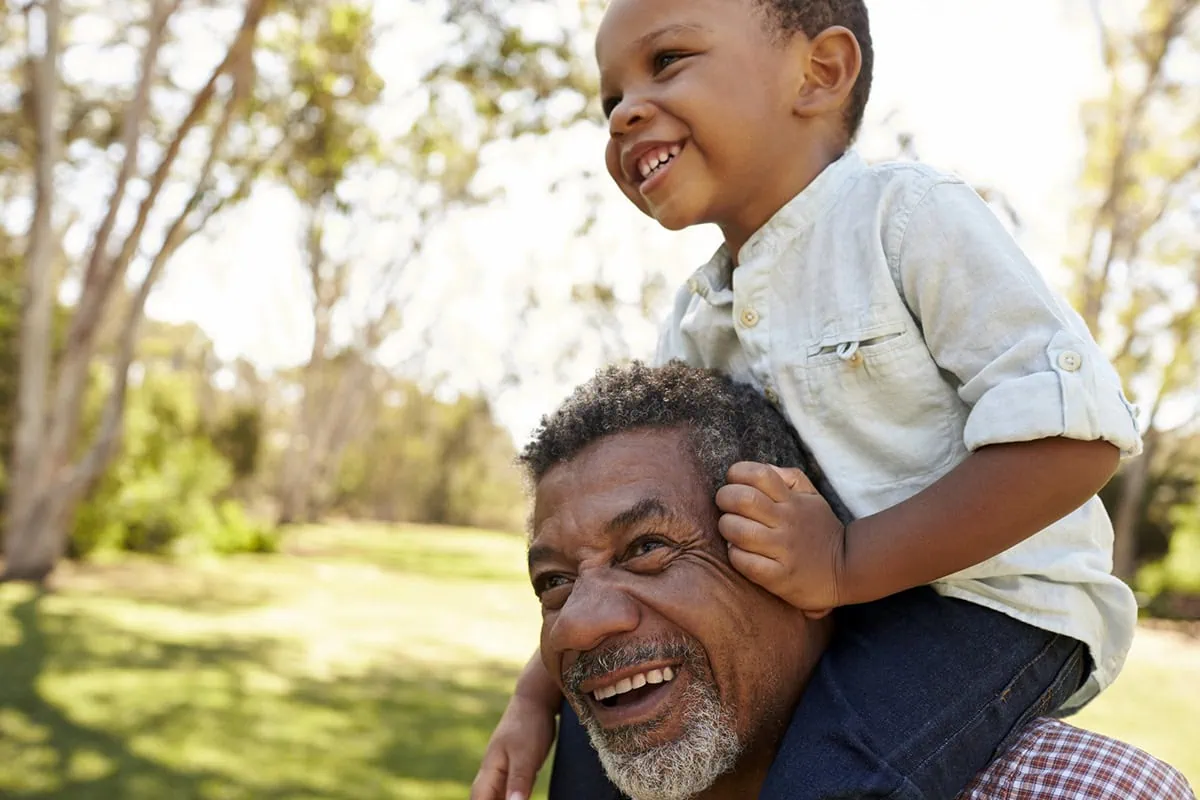 The anti-anxiety retirement checklist: 10 ways to ease retirement fears 3 a grandfather holds his grandson on his shoulders.