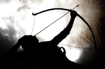 A silhouette of an archer against a cloudy sky.
