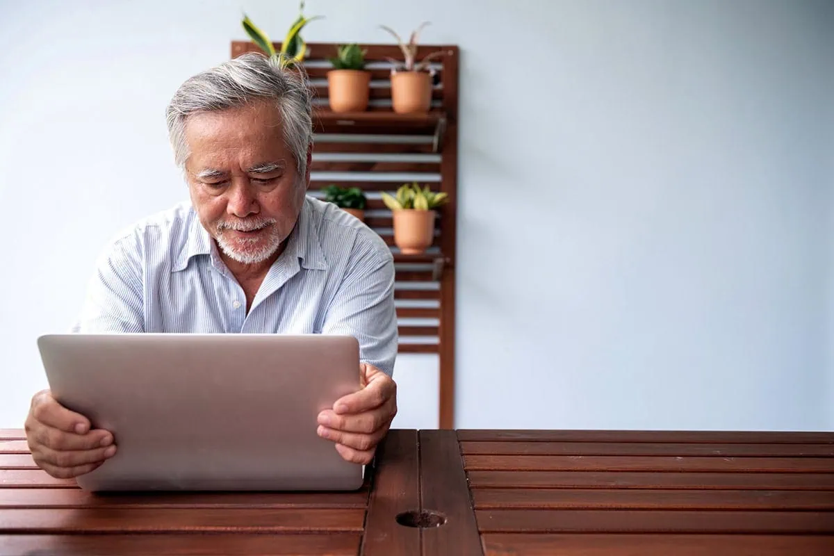 Seeking Alternatives: Other Popular Stock Picking Services When Seeking Alpha Isn't Cutting It 6 An older man adjusts the monitor portion of his laptop.