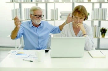 senior couple looking stressed in front of computer