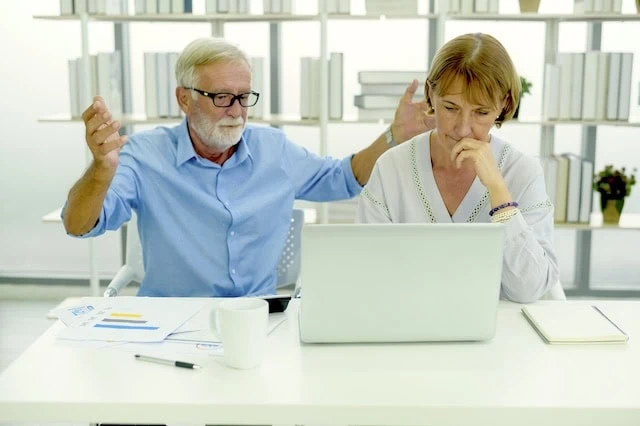 senior couple looking stressed in front of computer