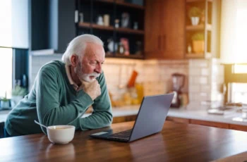 senior man breakfast kitchen cereal laptop 1200