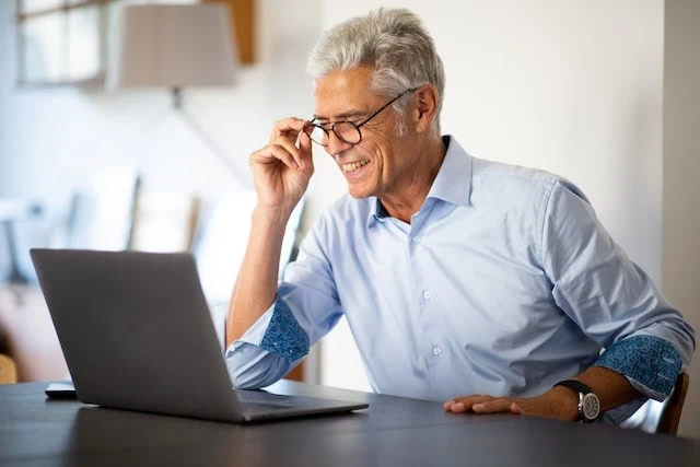 Close up businessman with glasses looking at laptop computer