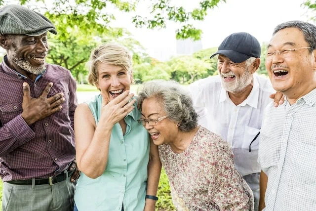 seniors laughing in a park happy elderly