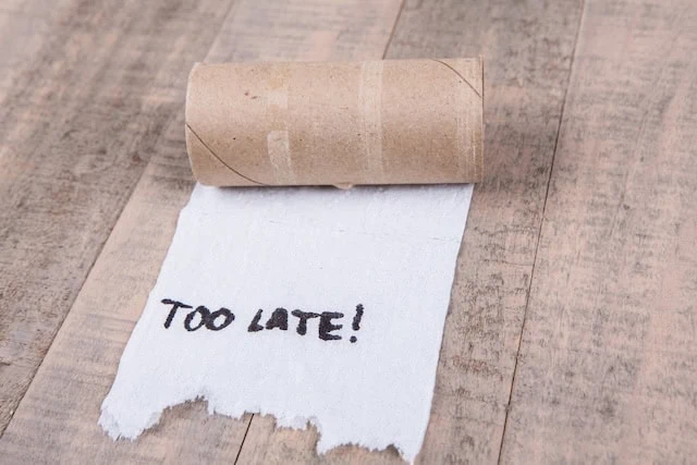 Toilet paper rolls out of paper with message isolated on a wood background