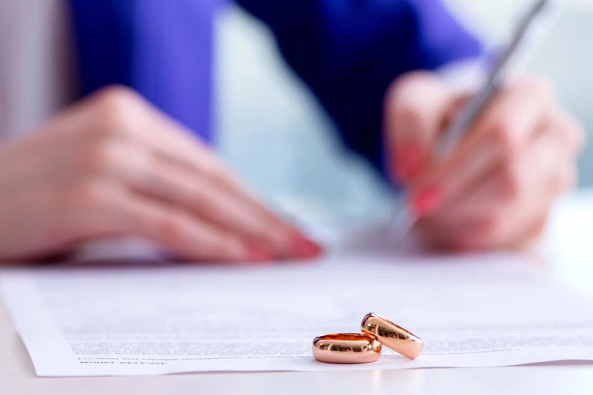 7 Financial Conversations You Should Have With Your Significant Other 9 signing prenuptial agreement wedding rings