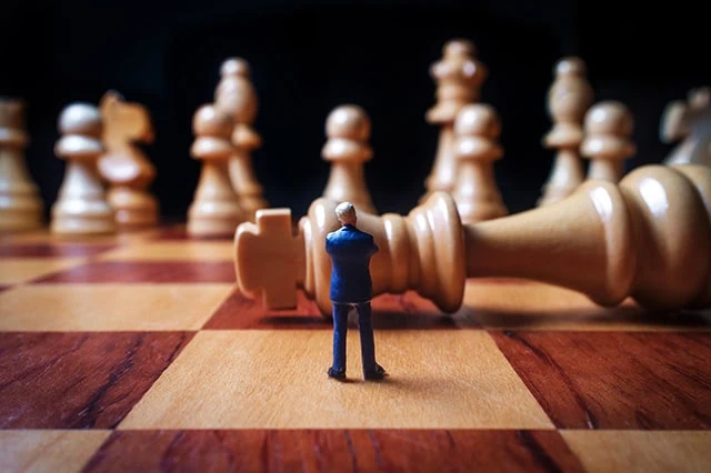 a miniature person on a chess board.