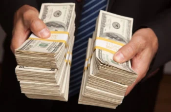 Businessman Handing Over Stacks of Hundred Dollar Bills.