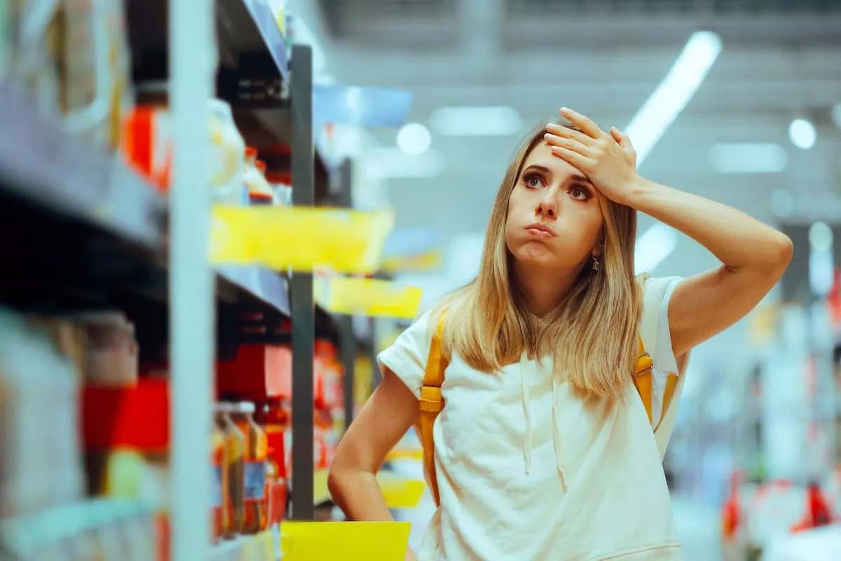 Lighter Bags, Heavier Bills: 16 Shameless Examples of Shrinkflation Caught in the Wild 2 stressed shopping grocery store younger woman