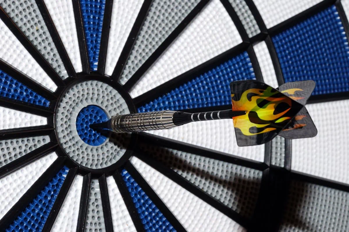 a dart with a fire illustration on the wings in a blue bull's-eye.