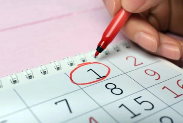 a person circles the first of the month on a calendar.