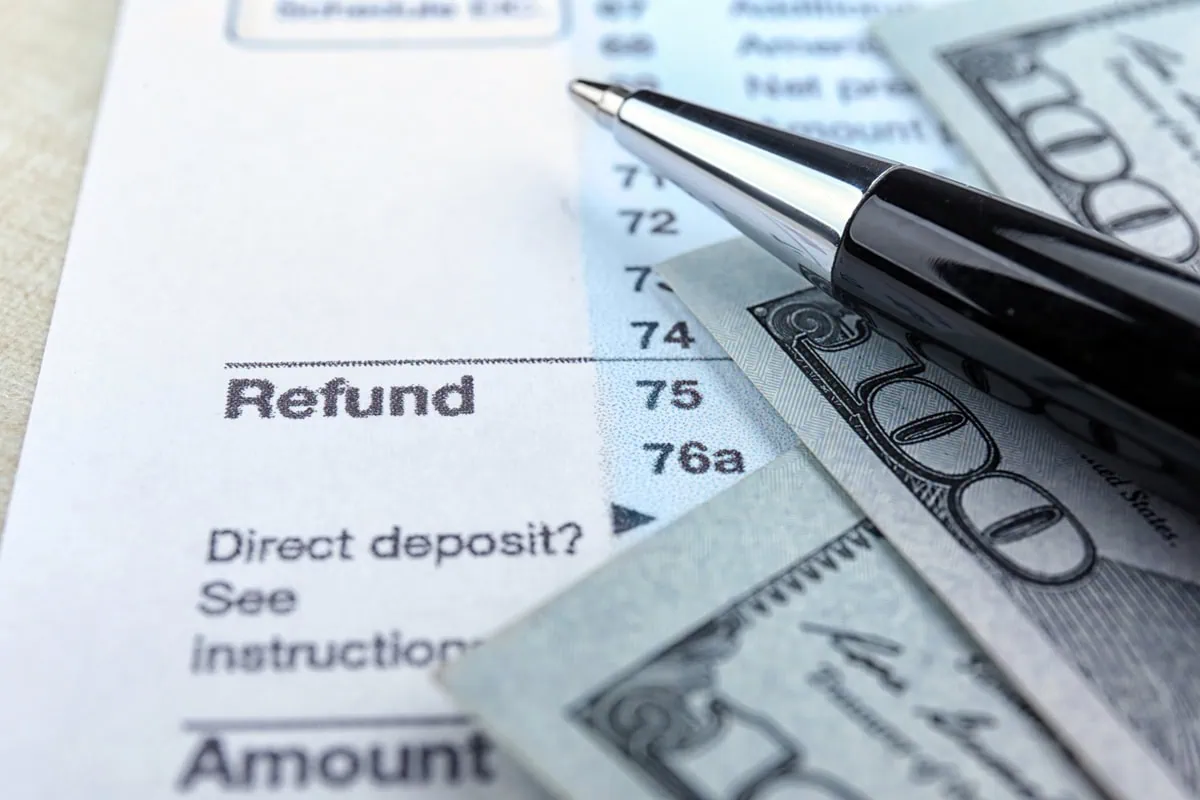 What Was the Average Tax Refund in 2026? 3 a pen and money sit on top of a tax return focused on the word refund.