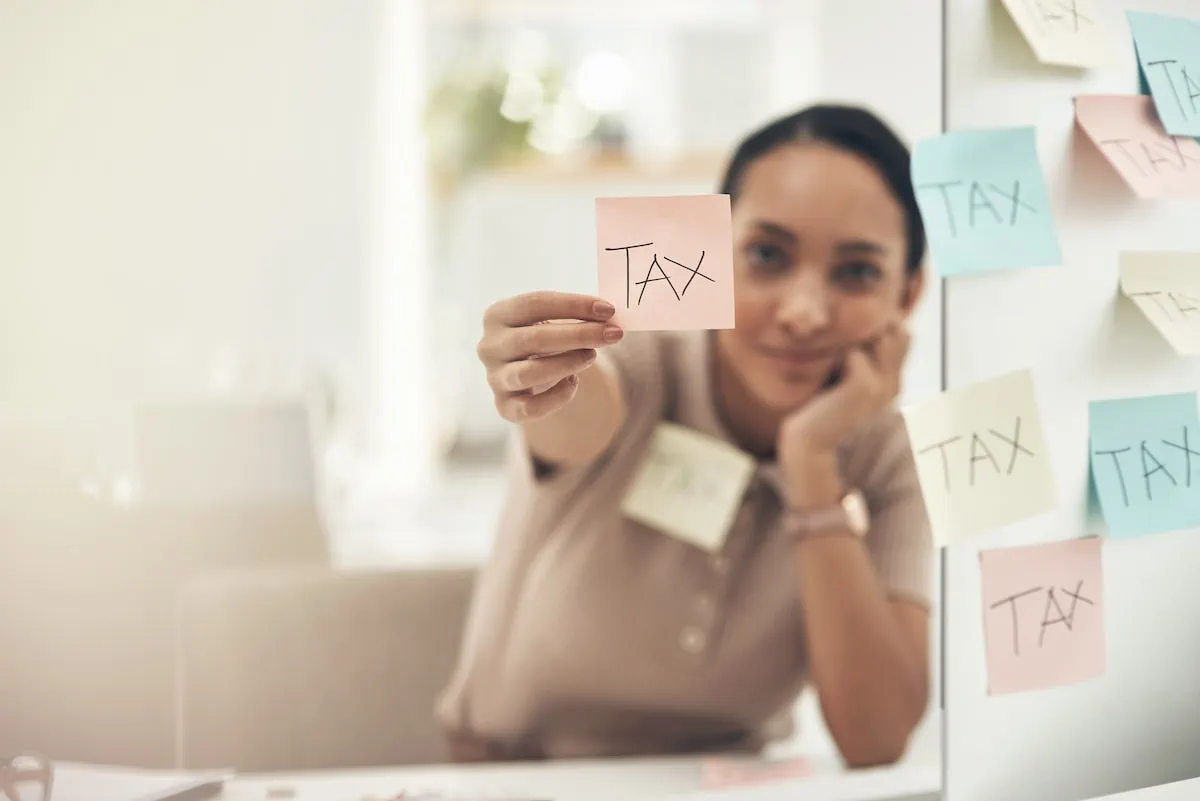 woman holding post-it note with tax written