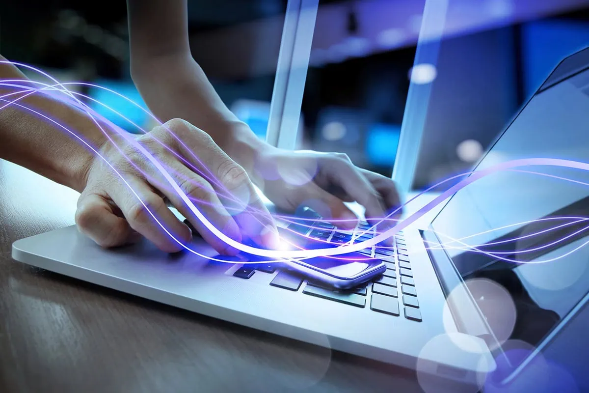 The 12 Best Vanguard ETFs You Can Own Right Now 6 concept art of a purple light beam moving across a person's hand and onto their laptop.