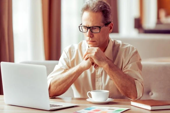 thinking retirement over laptop coffee 1200