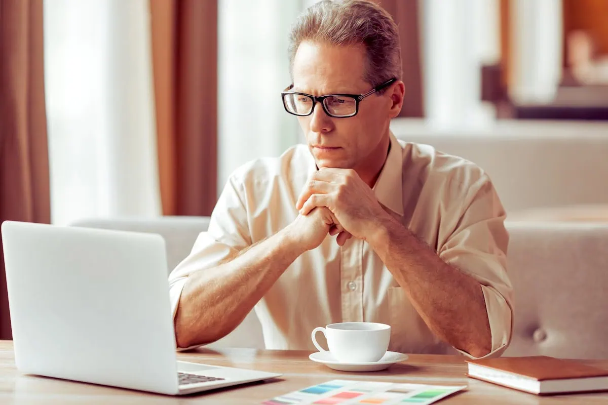 thinking retirement over laptop coffee 1200